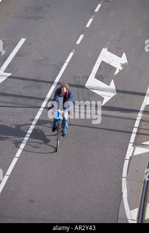 HOLLAND AMSTERDAM OVERHEAD VIEW OF MAN ON BIKE TRAVELING ON ROAD WITH ARROW SIGN Stock Photo