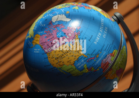 Globe on desktop showing North America and shadows from vertical blinds Stock Photo