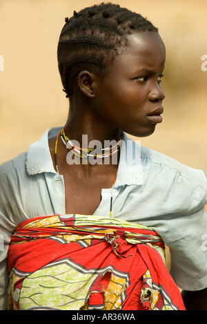 A beautiful young Ugandan black girl leaning on a bench. She has a ...