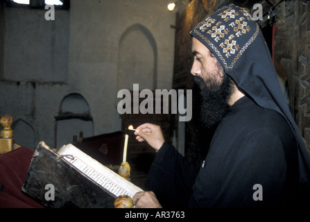 A Coptic monk reading the bible, Deir al-Muharraq, Egypt Stock Photo