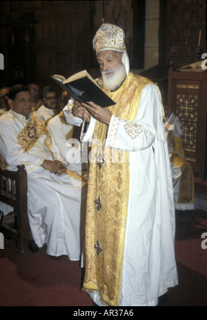 Bishop reads from a bible during an Egyptian Coptic Christian church service in Luxor, Egypt Stock Photo