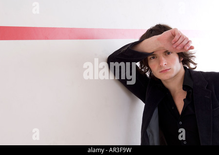 young man leaning against a wall Stock Photo