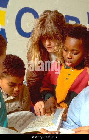 Tutor and youths age 20 and 10 in community after school study program. St Paul Minnesota USA Stock Photo