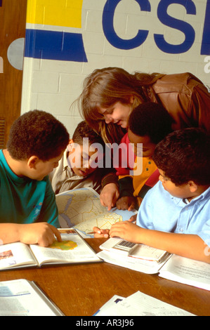 Tutor and youths age 20 and 10 in community after school study program. St Paul Minnesota USA Stock Photo