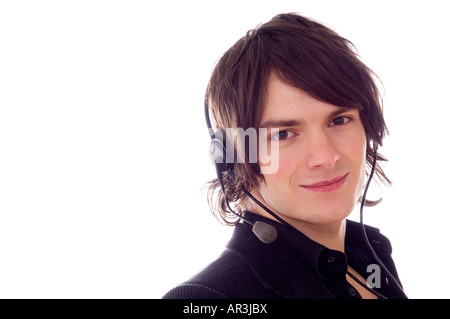 young man in a call centre speaking with a telephone headset smiling Stock Photo