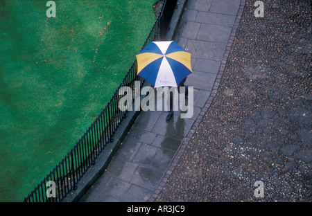 Man walking in rain with umbrella. Stock Photo