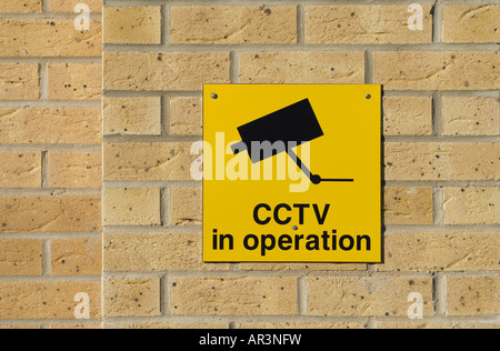 cctv in operation sign on brick wall Stock Photo