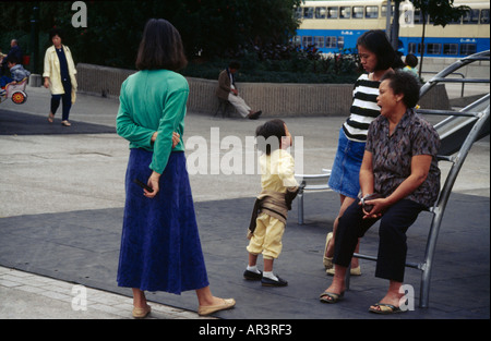 Aberdeen Harbour Hong Kong Child Playing with Child Minder Stock Photo