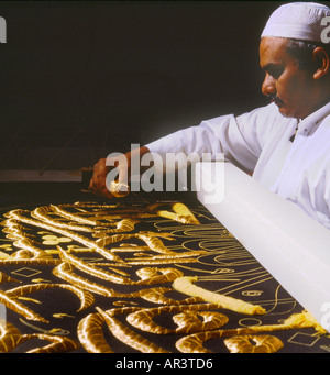 Makkah Saudi Arabia Kiswa Factory Man Embroidering Black Cloth with Gold Thread Stock Photo