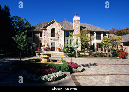 FRONT ENTRANCE GARDEN OF LUXURY MINNESOTA HOME INCLUDES A FOUNTAIN, ALYSSUM, ASTERS AND GINGKO BILOBA TREES.  FALL. Stock Photo