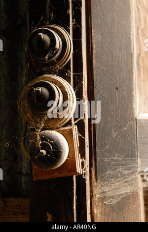 three old lightswitches covered in cobwebs Stock Photo