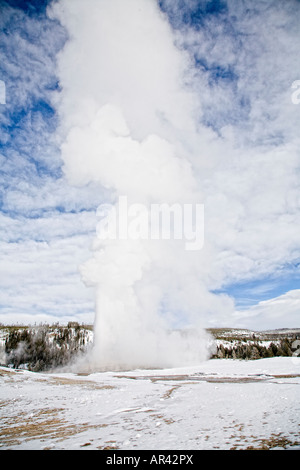 Yellowstone National Park in winter snow covered erupting Old Faithful Geyser Stock Photo