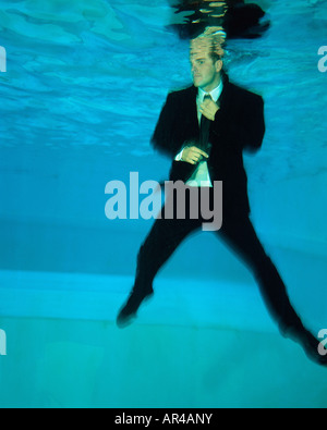 A man adjusts his tie under the water Stock Photo
