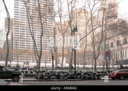 Garbage bags stacked on the sidewalk beside Bryant Park. Early morning in winter. New York city. USA. Stock Photo