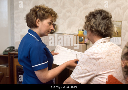 district nurse visiting elderly woman at home NHS Stock Photo