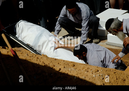 Orthodox Jewish pallbearers lower the body of renowned Nazi-hunter Simon Wiesenthal into a grave at his funeral in the town of Herzliya in Israel Stock Photo