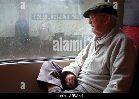 Elderly senior man looking out of train window Stock Photo