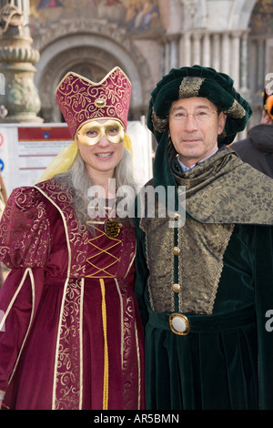 Revellers in costume at the Venice carnival, in St Mark's Square by the Doges Palace, Italy Stock Photo