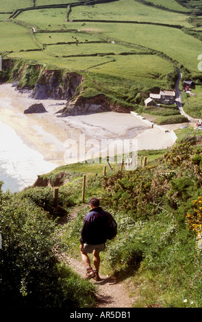 Man walking down path towards Hemmick beach near Gorran Haven on the south coast of Cornwall, UK Stock Photo