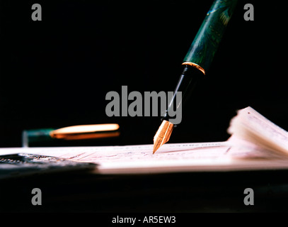 A portrait of someone writing a cheque with an ornate fountain pen Stock Photo