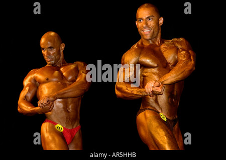Bodybuilders performing a side chest pose at a fitness and figure competition in Haifa Israel Stock Photo