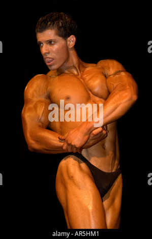 Bodybuilder performing a side chest pose at a fitness and figure competition in Haifa Israel Stock Photo