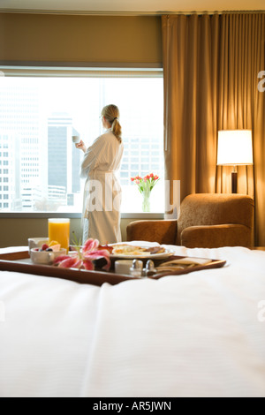 Bed in breakfast tray laying on bed with mid adult woman in background Stock Photo