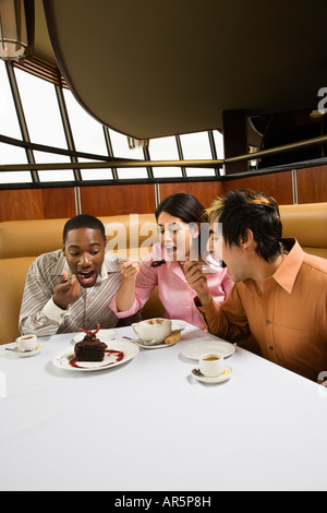 Small group of mid adult friends eating dessert at a restaurant Stock Photo