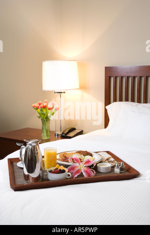 Breakfast tray laying on white bed in upscale hotel Stock Photo