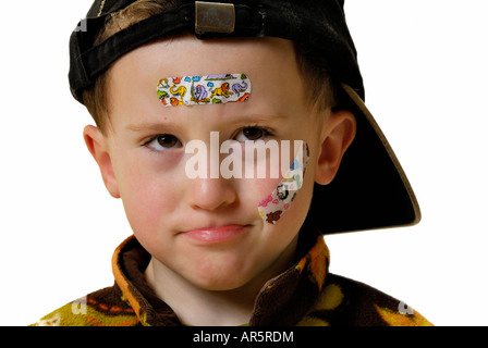 BOY PORTRAIT WITH ADHESIVE PLASTERS BAND AID ON WHITE BACKGROUND Stock Photo