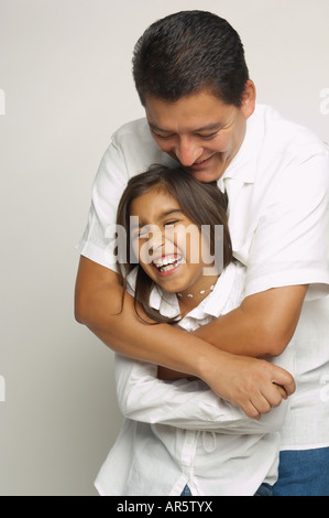 Hispanic father and daughter hugging