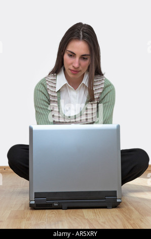 Young woman sitting on floor using laptop Stock Photo
