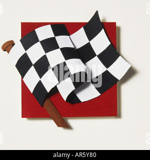 Model of black and white chequered flag flying on short wooden pole, against red background. Stock Photo