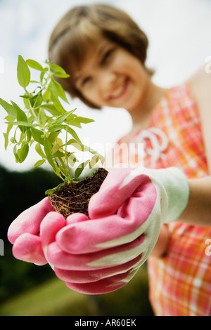 Girl holding small plant Stock Photo