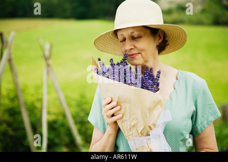 Woman smelling bouquet of flowers Stock Photo