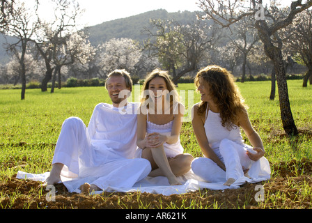 MR Three friends, a spanish woman, a brazilian woman and a sweedish man, enjoying themselves in the fields of Ibiza, Spain Stock Photo