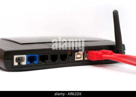 Backsite of a router isolated on white background Two of the ports have red network cables plugged in Stock Photo