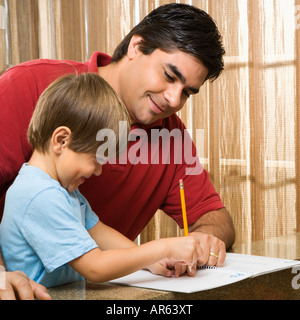 Hispanic father helping son with homework Stock Photo