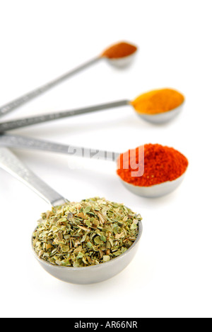 Assorted spices in metal measuring spoons on white background Stock Photo