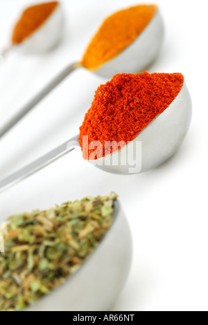 Assorted spices in metal measuring spoons on white background Stock Photo