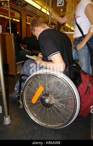 A young man on wheel chair in the subway train Stock Photo