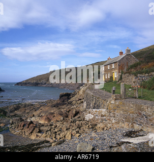 Quay Cottage a stone building sitting on the edge of a rocky foreshore with spectacular views out to sea at Portquin Bay Stock Photo
