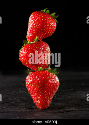 stack of Fresh English organic strawberries against a black background, stylised creative concept photo Stock Photo