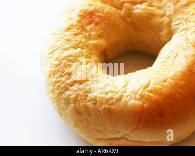 Lone plain bagel against white background in soft but strong white light. Stock Photo