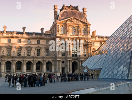 Visitors queue up early in the morning at the Pyramid entrance to The Louvre Museum Paris France Europe Stock Photo