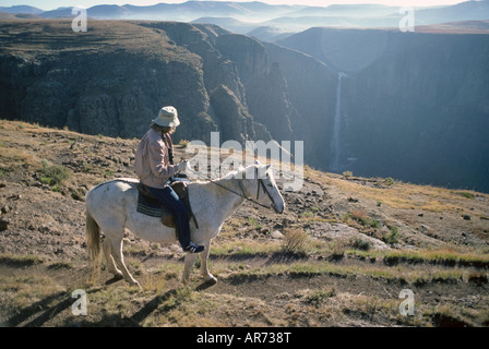 A visitor on a Basotho pony visits an overview of Maletsunyane Falls highest waterfall in southern Africa in the Drakensburg Stock Photo