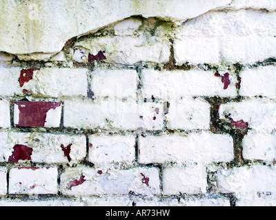 Grungy brick cracked wall painted in white Stock Photo