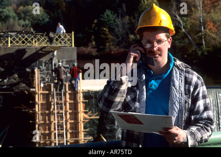 Construction worker on site with cell phone to communicate Stock Photo