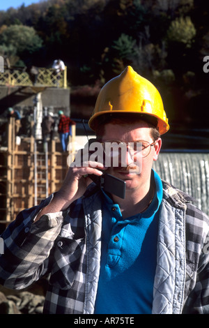 Construction worker on site with cell phone to communicate Stock Photo