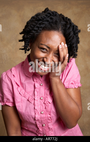African woman laughing with hand on face Stock Photo
